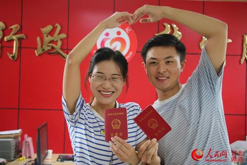 图为8月7日,在河北省广平县民政局婚姻登记处,一对新人领取结婚证后在